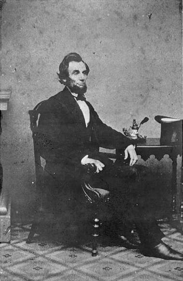 Alexander Gardner, Full length portrait of Lincoln seated next to a small table, Feb. 24 1861. Library of Congress, Prints and Photographs Division. Washington D.C.